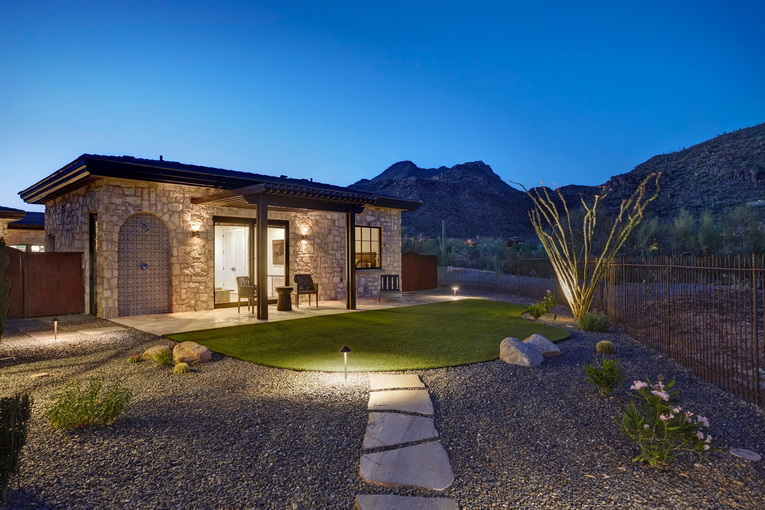 Guest casita at dusk with a lawn and flagstone path