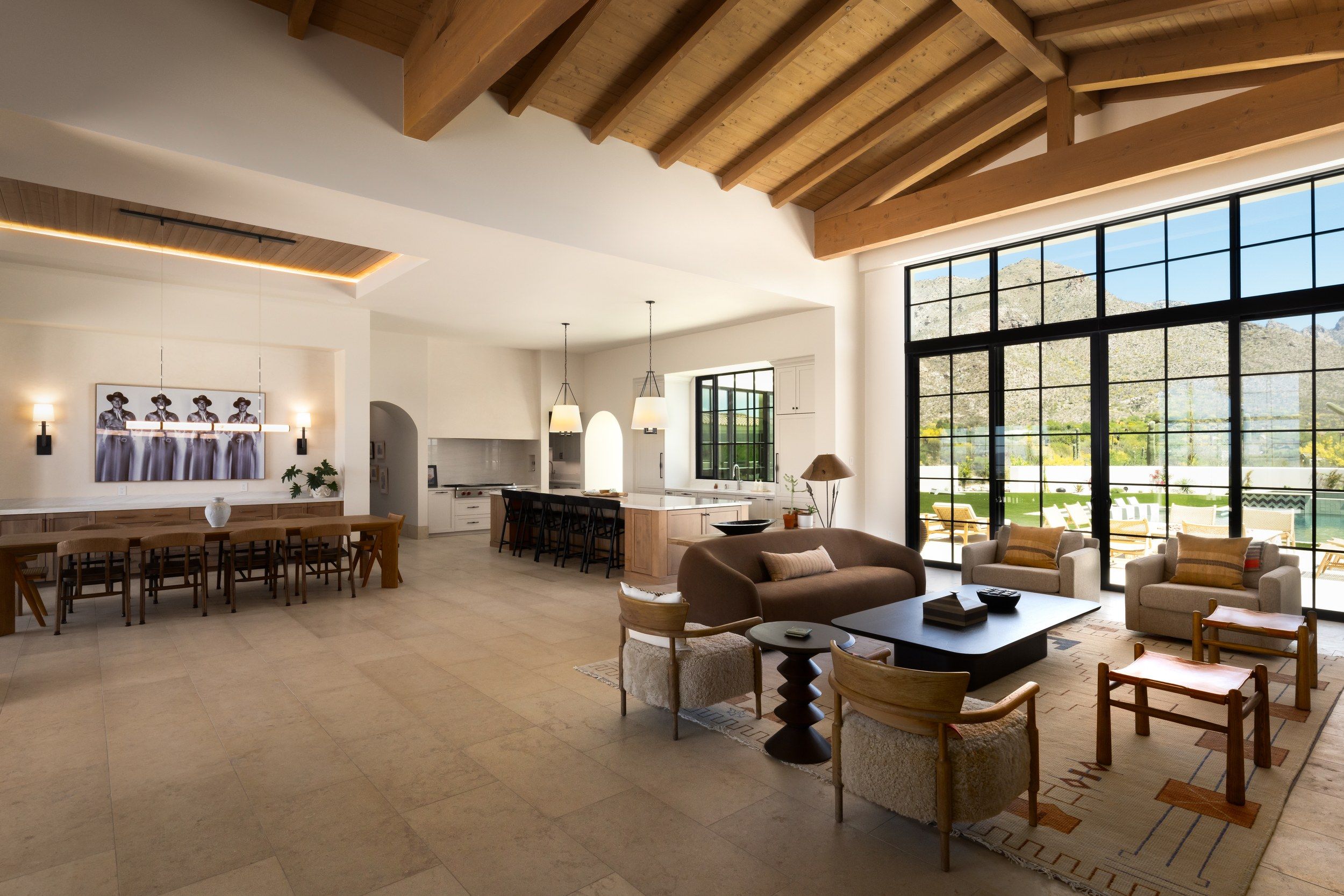 Open living and dining space beneath a vaulted beamed ceiling