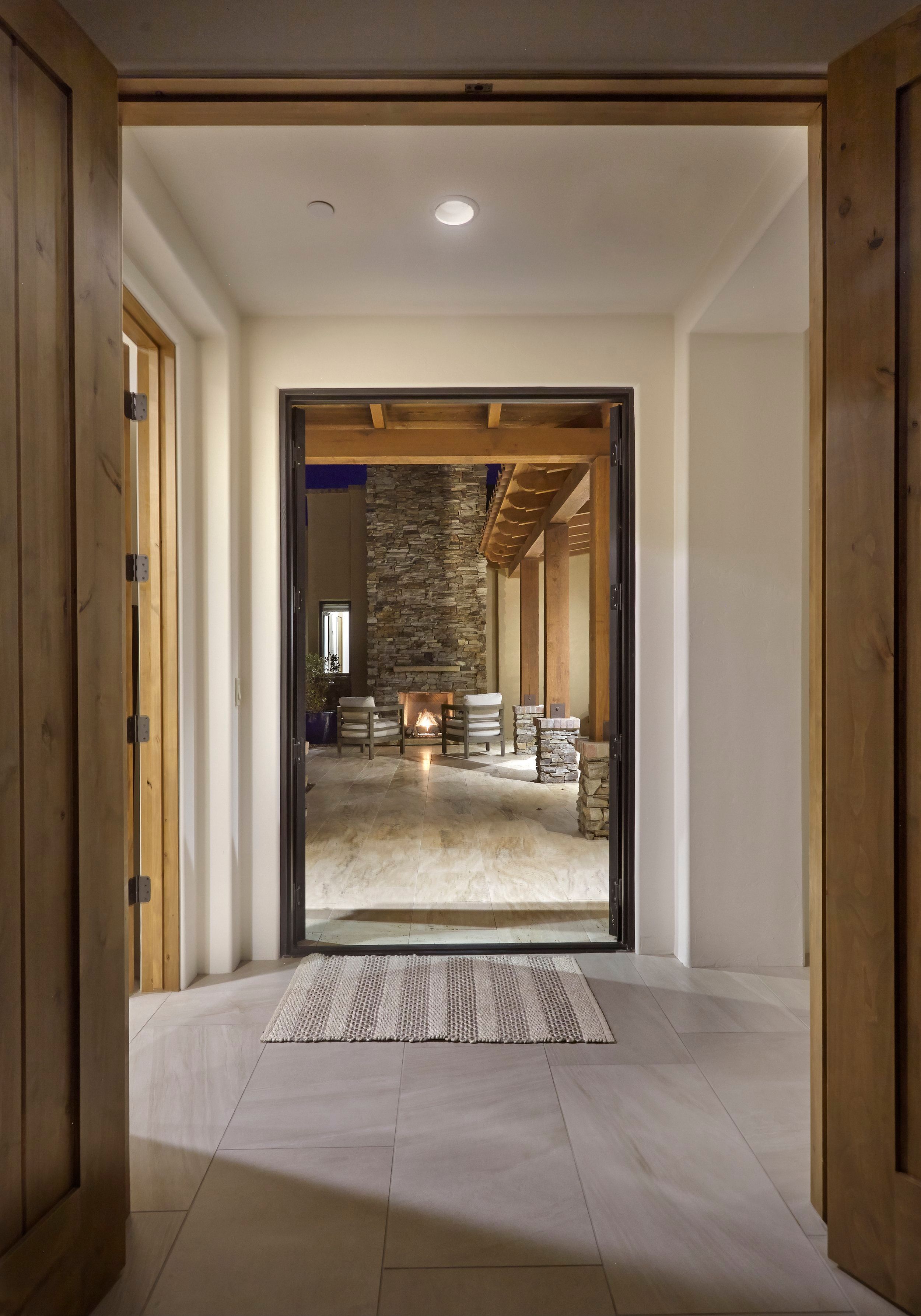 Entry hall looking through to a stone fireplace and covered patio beyond