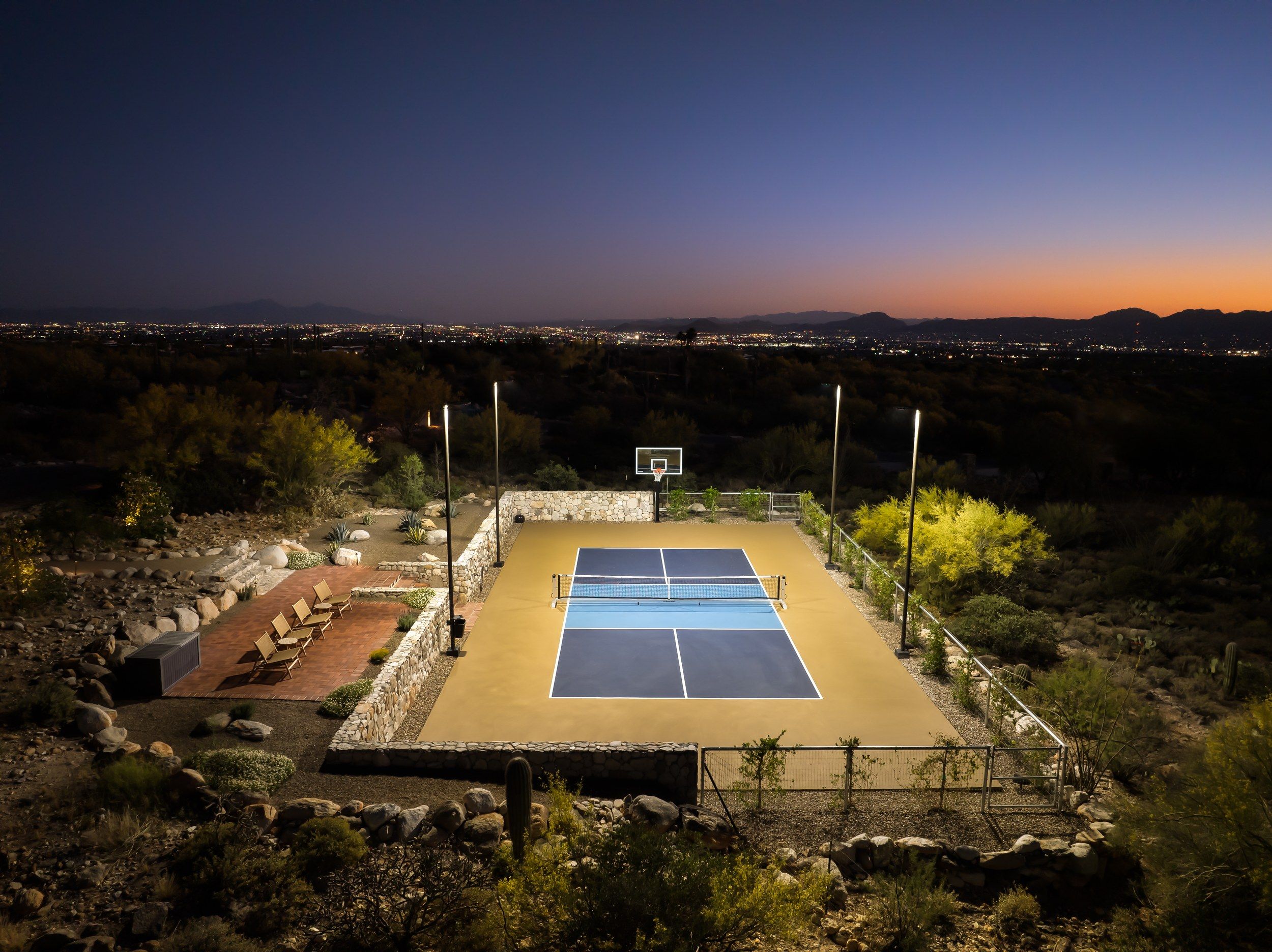 Sport court lit at night above the city lights